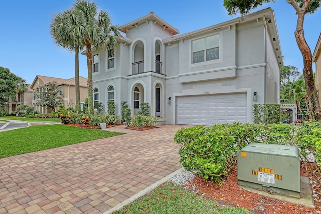 8086 Bautista Way, Palm Beach Gardens, FL 33418 - view of front of property with an attached garage, stucco siding, a front yard, decorative driveway, and a balcony