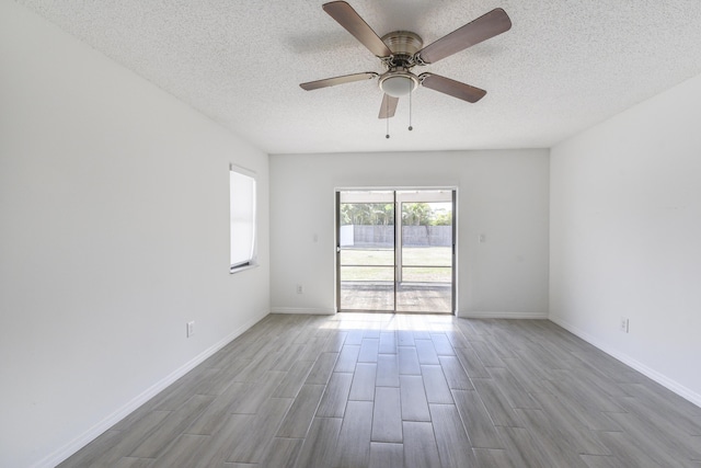 1168 SE Clifton Ln, Port Saint Lucie, FL 34983 - unfurnished room featuring wood finished floors, a textured ceiling, ceiling fan, and baseboards