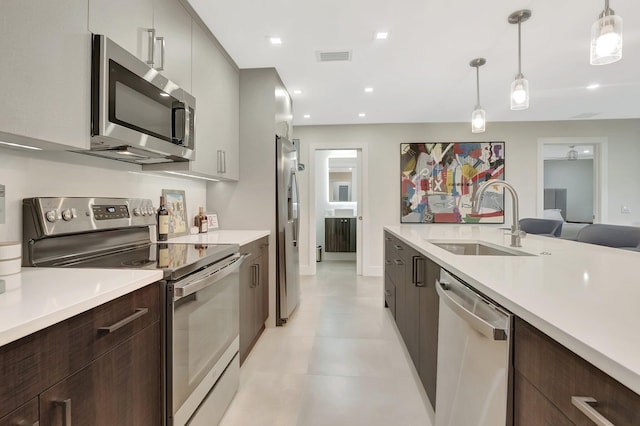 kitchen featuring modern cabinets, a sink, light countertops, and appliances with stainless steel finishes