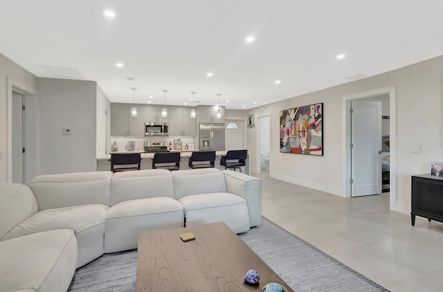 living area with baseboards, recessed lighting, and finished concrete floors