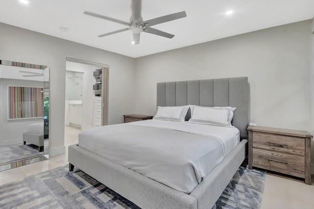 bedroom with light tile patterned floors, baseboards, ensuite bath, and ceiling fan
