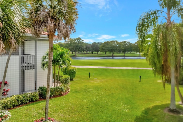 surrounding community with a water view and a lawn