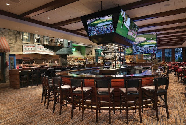 bar with a community bar and carpet floors