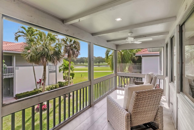 sunroom with beamed ceiling and a ceiling fan