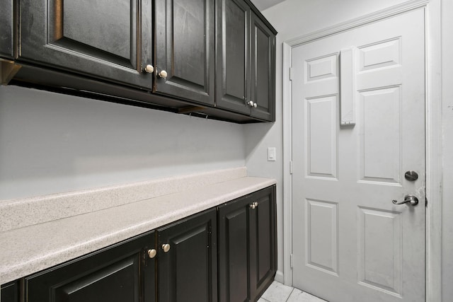 interior space featuring marble finish floor, light countertops, and dark cabinets