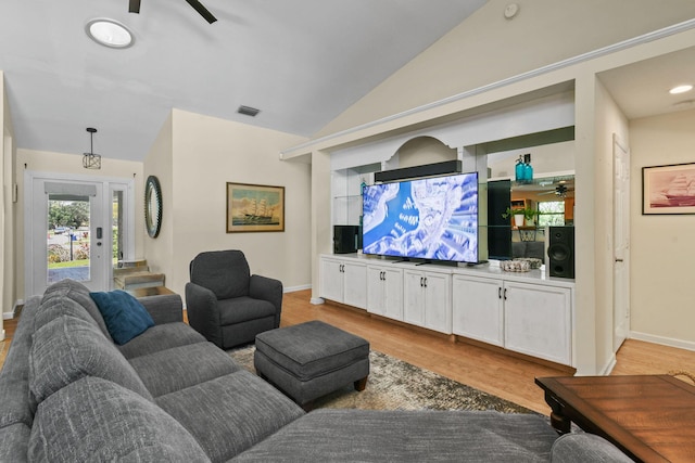 living area with vaulted ceiling, visible vents, light wood-style floors, and a ceiling fan