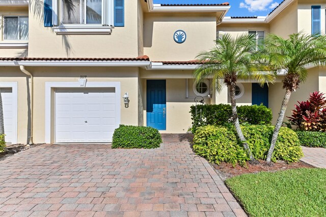 3119 N Evergreen Cir, Boynton Beach, FL 33426 - view of front of home featuring a garage, stucco siding, and decorative driveway