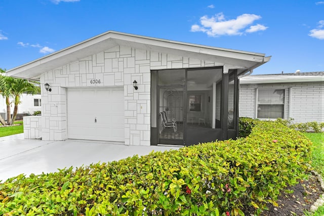 6306 Dusenburg Rd, Delray Beach, FL 33484 - view of front facade with a garage, driveway, and a sunroom