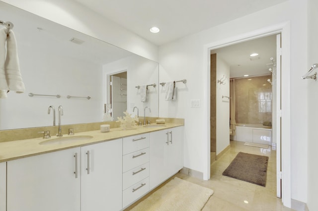 full bath featuring a washtub, double vanity, recessed lighting, and a sink