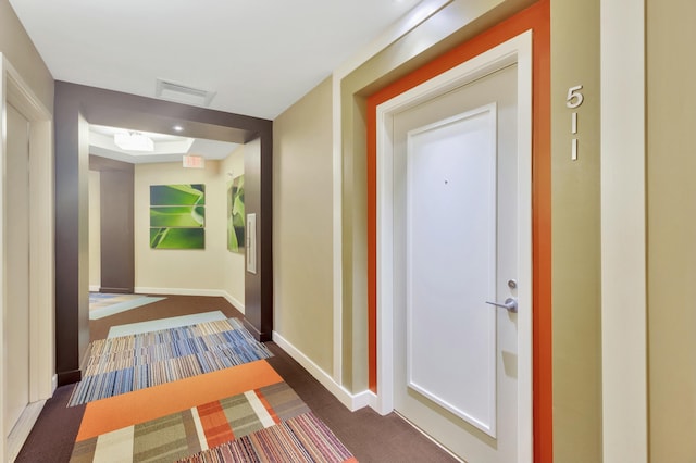 hallway featuring baseboards and visible vents