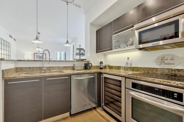 kitchen featuring beverage cooler, a sink, stone countertops, and appliances with stainless steel finishes