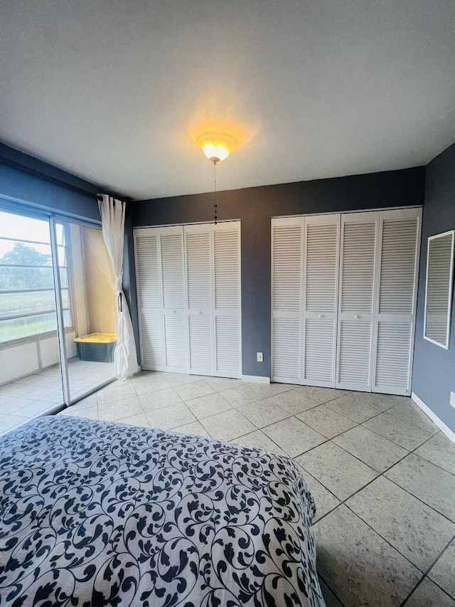 unfurnished bedroom featuring baseboards, multiple closets, and visible vents