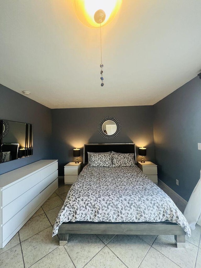tiled bedroom featuring baseboards