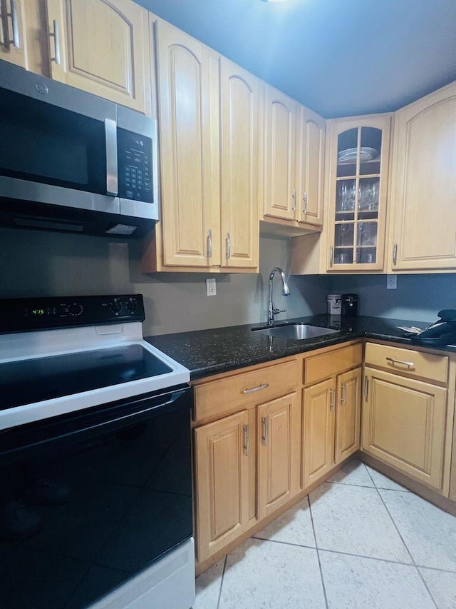 kitchen with a sink, range with electric cooktop, stainless steel microwave, glass insert cabinets, and light tile patterned floors