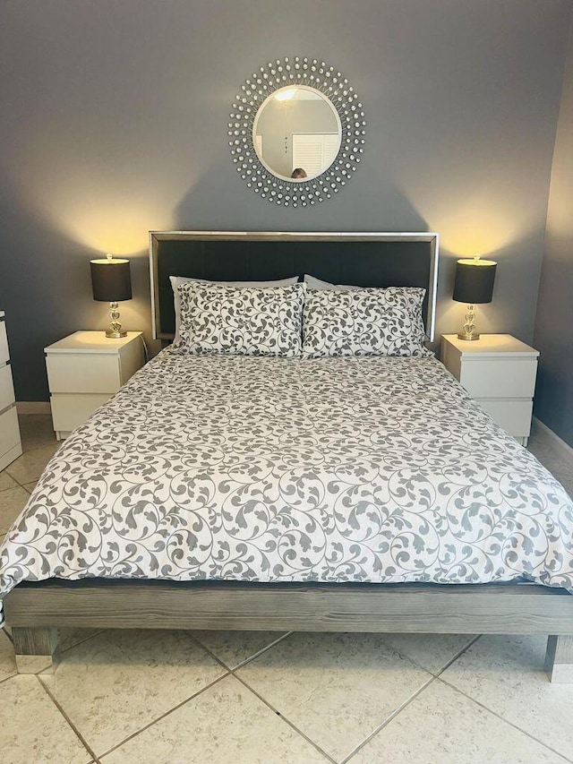 bedroom featuring baseboards and light tile patterned flooring