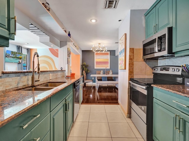 kitchen featuring light tile patterned flooring, a notable chandelier, a sink, appliances with stainless steel finishes, and visible vents