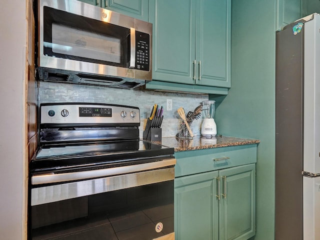 kitchen featuring green cabinets, decorative backsplash, dark stone countertops, and stainless steel appliances