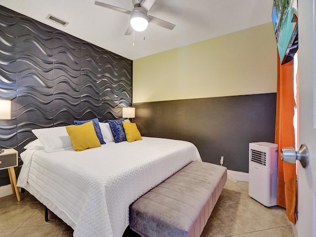 bedroom with visible vents, baseboards, ceiling fan, an accent wall, and light tile patterned floors