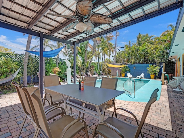 view of patio with a fenced backyard, outdoor dining area, ceiling fan, and a fenced in pool
