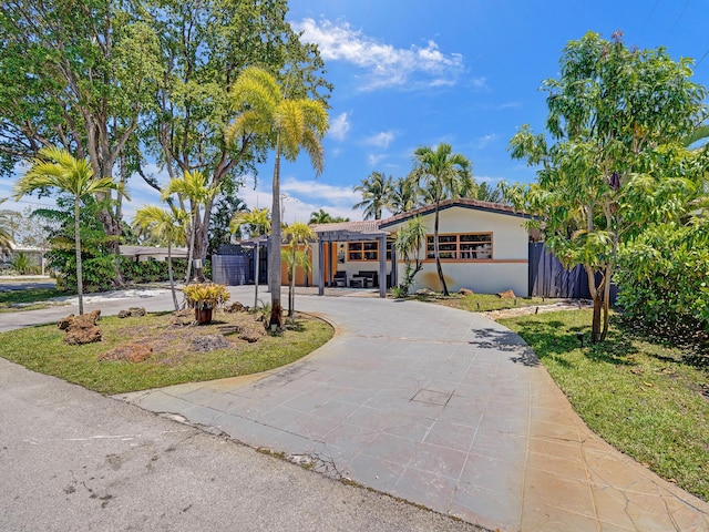 single story home with stucco siding, fence, and curved driveway