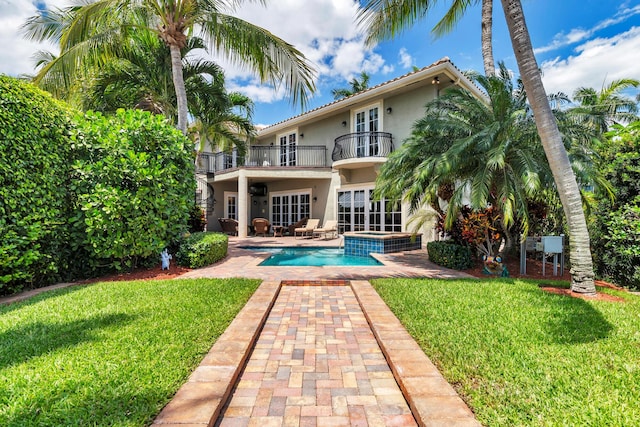 702 SE 7th St, Delray Beach, FL 33483 - back of house featuring a balcony, stucco siding, a patio area, and a lawn