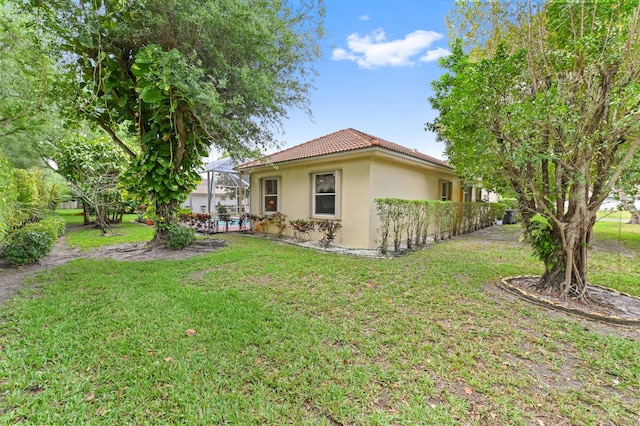 4346 Danielson Dr, Lake Worth, FL 33467 - rear view of house with stucco siding, a tile roof, a yard, and glass enclosure