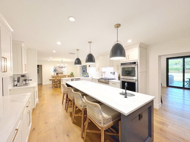 9600 Payton Ct, Boynton Beach, FL 33472 - kitchen featuring appliances with stainless steel finishes, light wood-style floors, recessed lighting, white cabinets, and light stone countertops