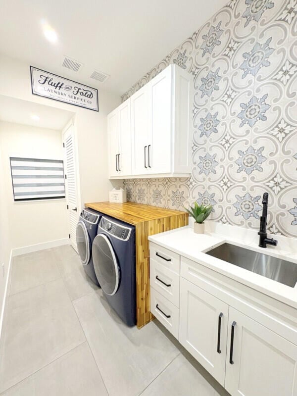 9600 Payton Ct, Boynton Beach, FL 33472 - laundry room featuring cabinet space, separate washer and dryer, light tile patterned floors, and baseboards