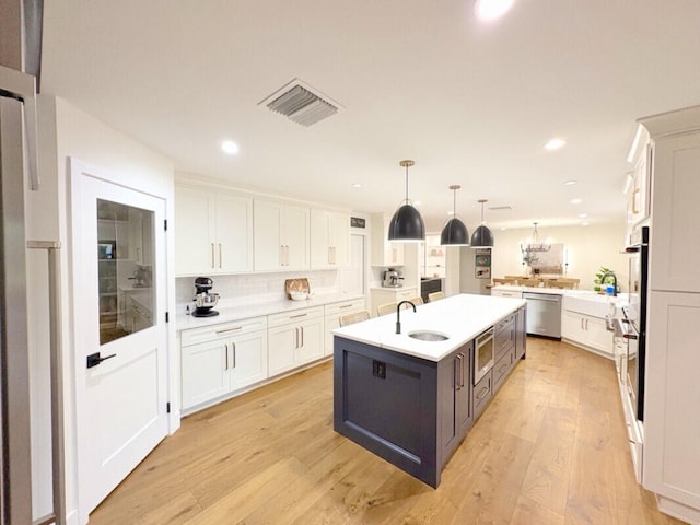 9600 Payton Ct, Boynton Beach, FL 33472 - kitchen with appliances with stainless steel finishes, a sink, a kitchen island with sink, white cabinetry, and recessed lighting