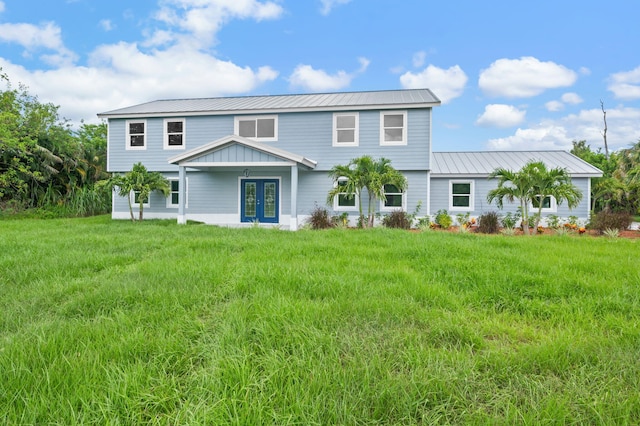 6008 S Citrus Ave, Fort Pierce, FL 34982 - view of front of home with french doors, a front yard, and a metal roof