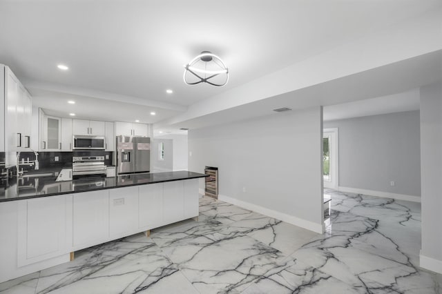 6008 S Citrus Ave, Fort Pierce, FL 34982 - kitchen featuring appliances with stainless steel finishes, light marble finish flooring, recessed lighting, a peninsula, and glass insert cabinets