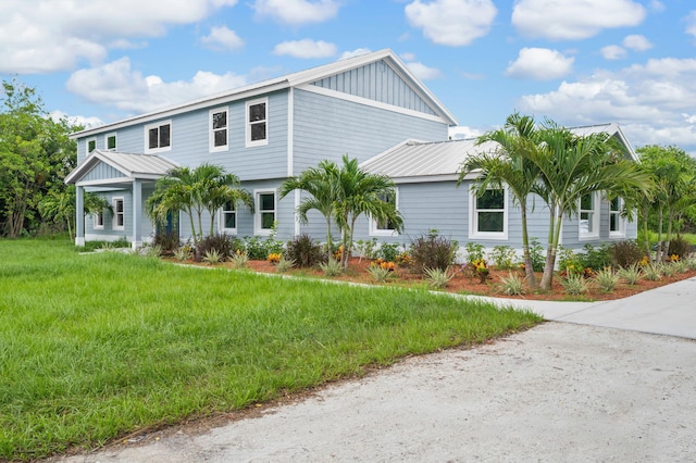 6008 S Citrus Ave, Fort Pierce, FL 34982 - view of front of home featuring board and batten siding, a front yard, and a metal roof