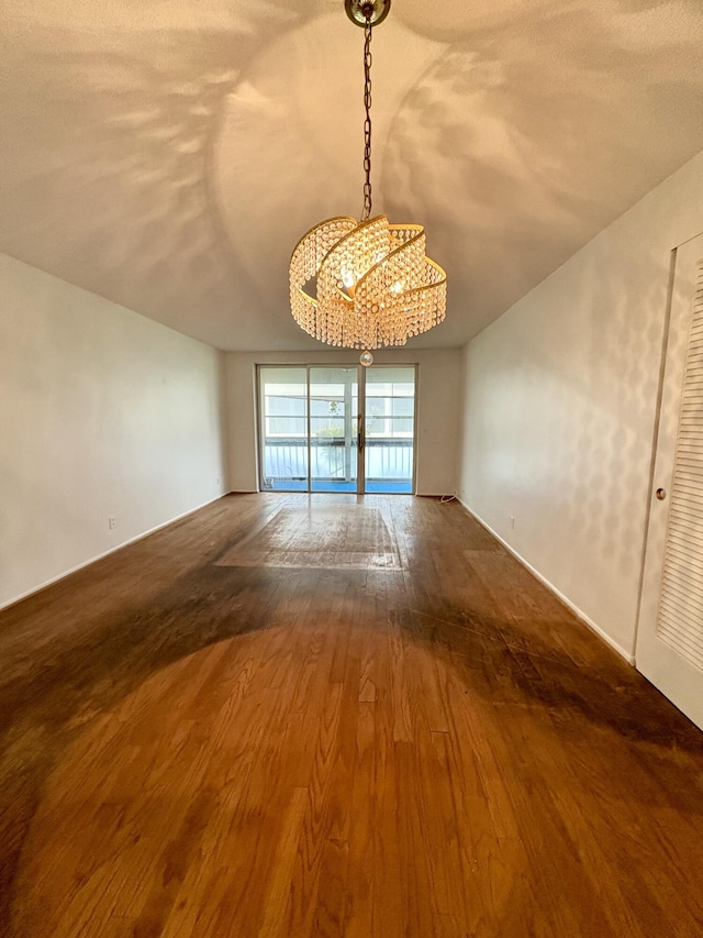 2540 Boundbrook Blvd Unit 110, Palm Springs, FL 33406 - empty room with a chandelier and wood finished floors