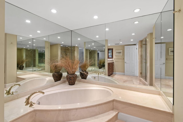 bathroom with a shower stall, a garden tub, vanity, and recessed lighting