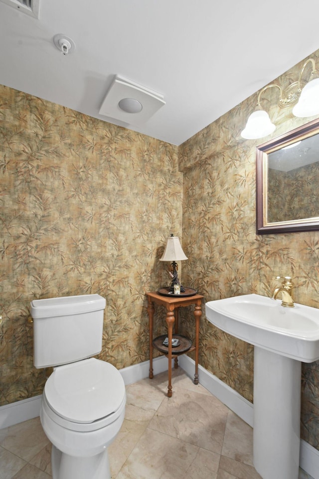 bathroom featuring baseboards and toilet
