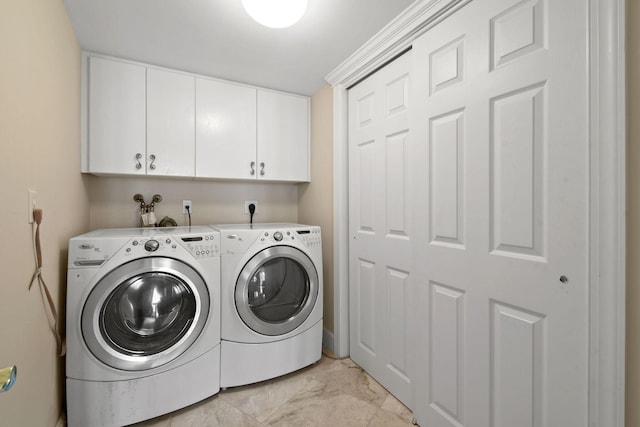 laundry room with cabinet space, washing machine and clothes dryer, and marble finish floor