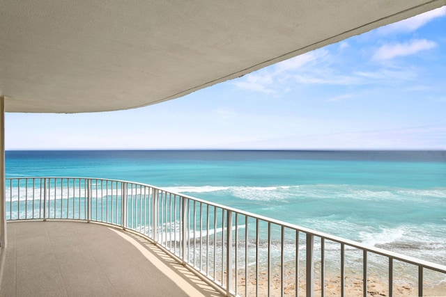 balcony featuring a water view and a view of the beach