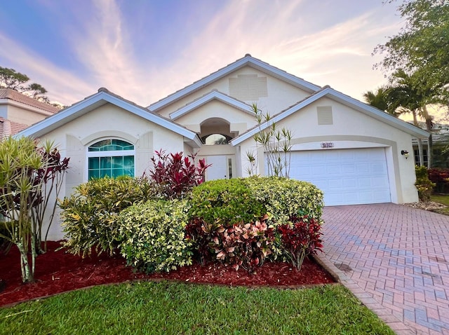 single story home featuring stucco siding, driveway, and a garage