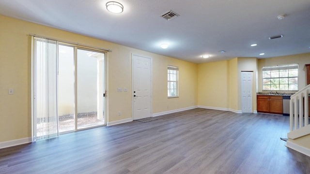 2558 SE Pineland Dr, Port Saint Lucie, FL 34952 - unfurnished living room featuring a healthy amount of sunlight, baseboards, dark wood finished floors, and visible vents