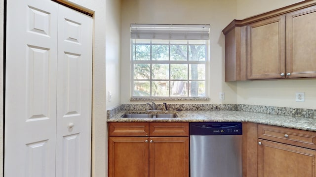 2558 SE Pineland Dr, Port Saint Lucie, FL 34952 - kitchen featuring a sink, stainless steel dishwasher, light stone counters, and brown cabinets