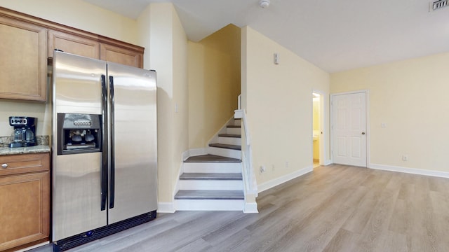 2558 SE Pineland Dr, Port Saint Lucie, FL 34952 - interior space featuring brown cabinetry, light wood-style flooring, and stainless steel refrigerator with ice dispenser