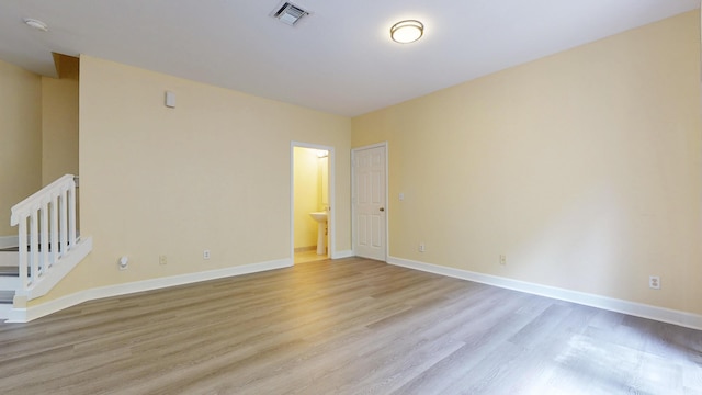 2558 SE Pineland Dr, Port Saint Lucie, FL 34952 - empty room with light wood-type flooring, baseboards, visible vents, and stairway
