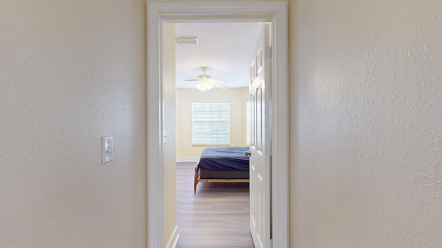 2558 SE Pineland Dr, Port Saint Lucie, FL 34952 - corridor featuring a textured wall, visible vents, baseboards, and wood finished floors