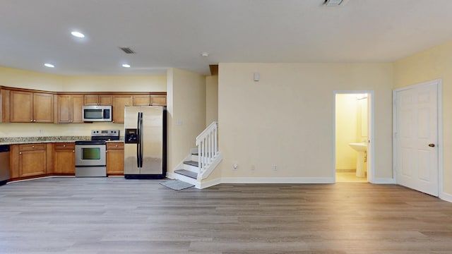 2558 SE Pineland Dr, Port Saint Lucie, FL 34952 - kitchen with light wood-style floors, visible vents, brown cabinetry, and appliances with stainless steel finishes