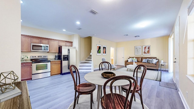 2558 SE Pineland Dr, Port Saint Lucie, FL 34952 - dining area featuring light wood-style floors, recessed lighting, stairway, and visible vents
