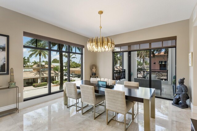 dining area with baseboards, a notable chandelier, and marble finish floor