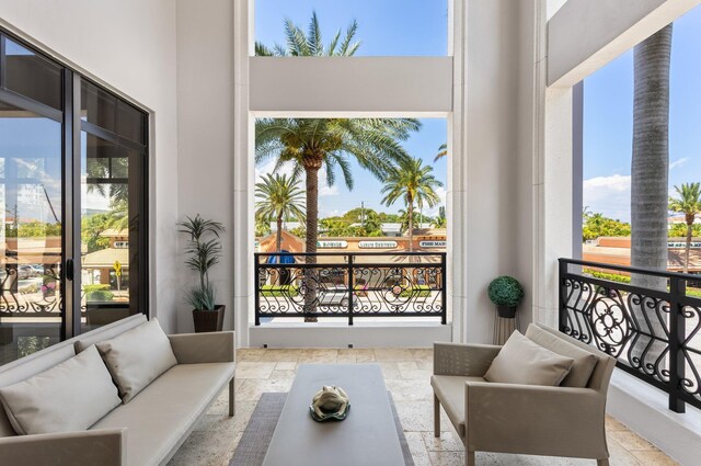 interior space with a high ceiling, plenty of natural light, and stone tile flooring