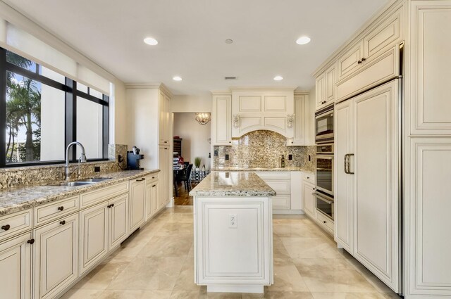 kitchen with a sink, cream cabinetry, and stainless steel appliances