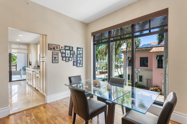 dining area with baseboards and light wood-style flooring