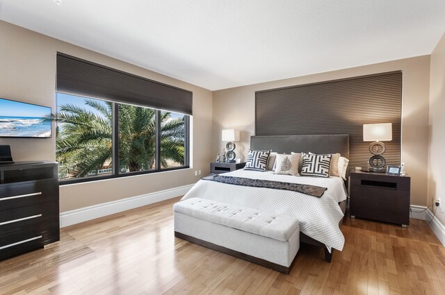 bedroom featuring baseboards and light wood finished floors
